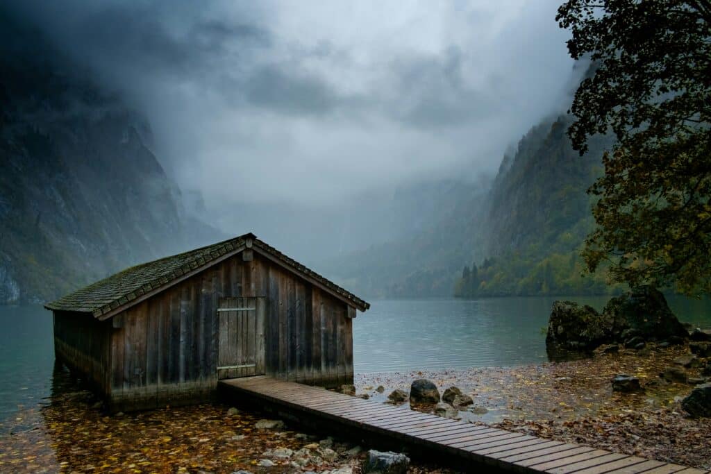 wooden shack by a lake on a cloudy day