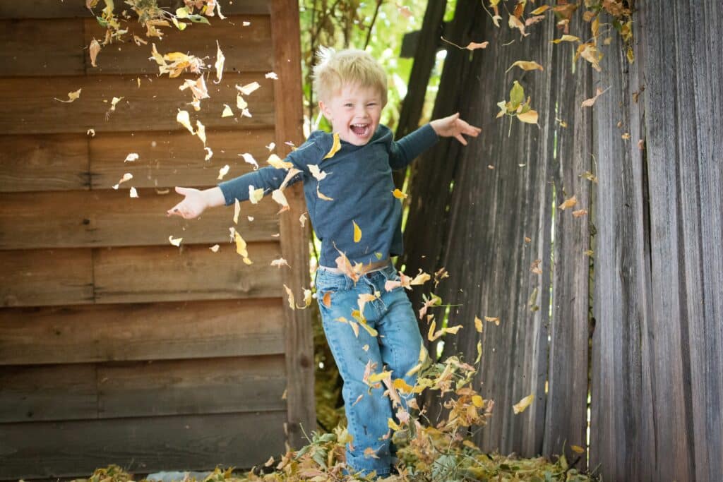child throwing leaves