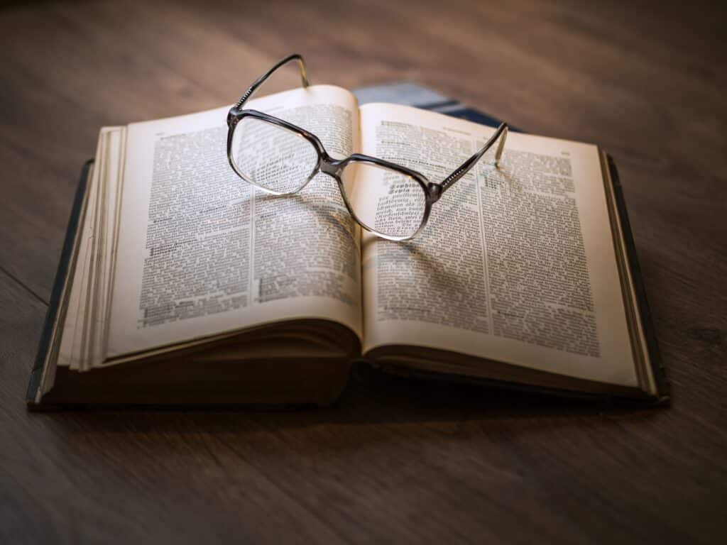 reading glasses sit on top of book