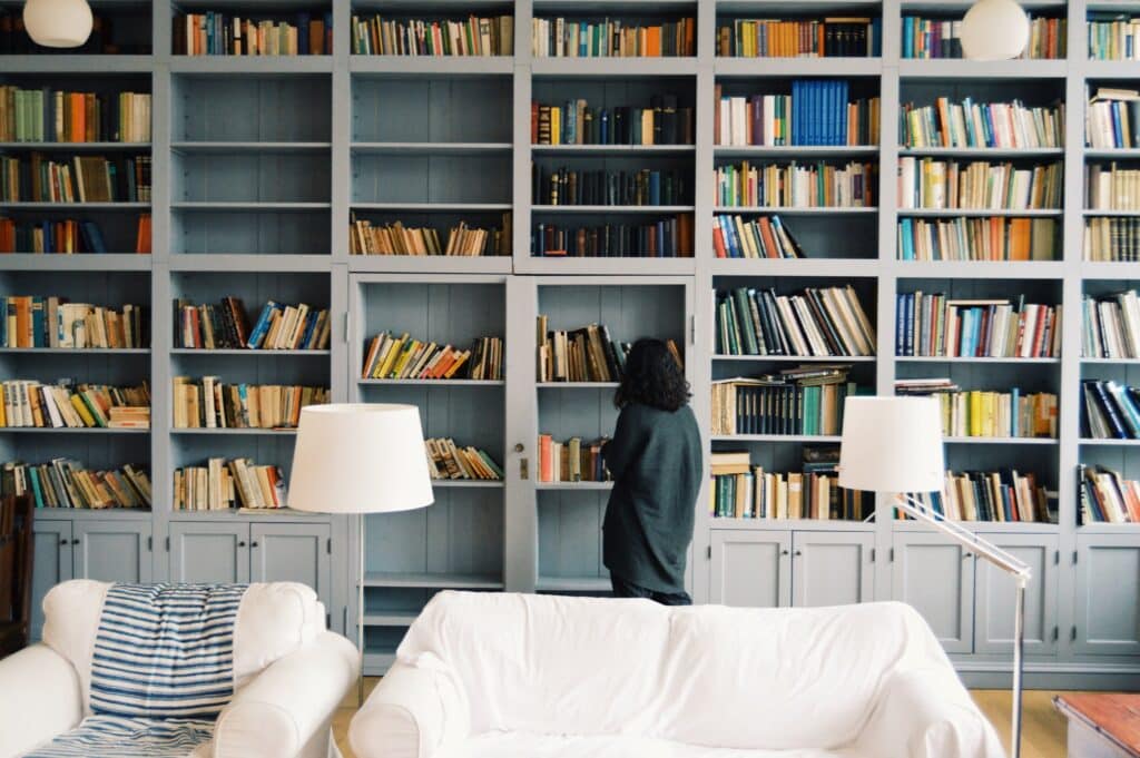 woman browsing shelves of home library