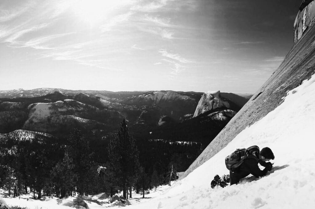 man climbing steep mountain