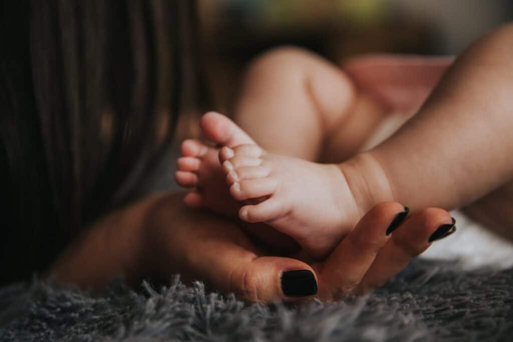 mother's hands cradle baby feet